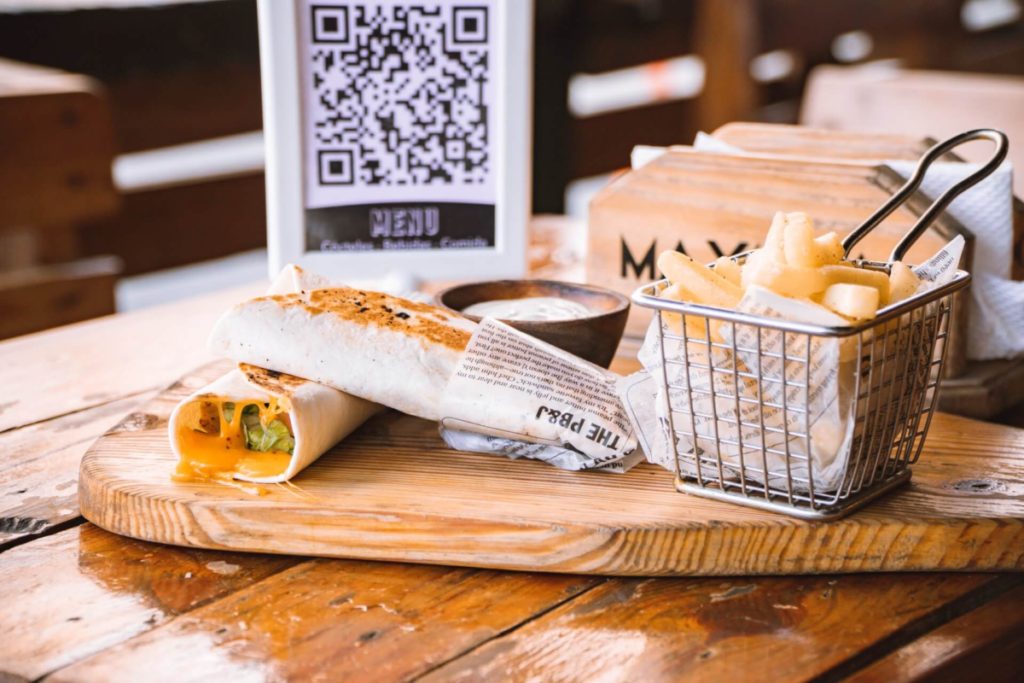 Sandwich wrap and fries in front of QR Code menu - Cyber Security Resources for Women QR Code Scams